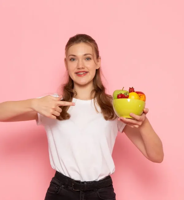 front-view-young-female-white-t-shirt-holding-plate-with-fresh-fruits-with-slight-smile-light-pink-wall-scaled ¿Diabetes gestacional? ¡Pide cita con una nutricionista experta en embarazo!